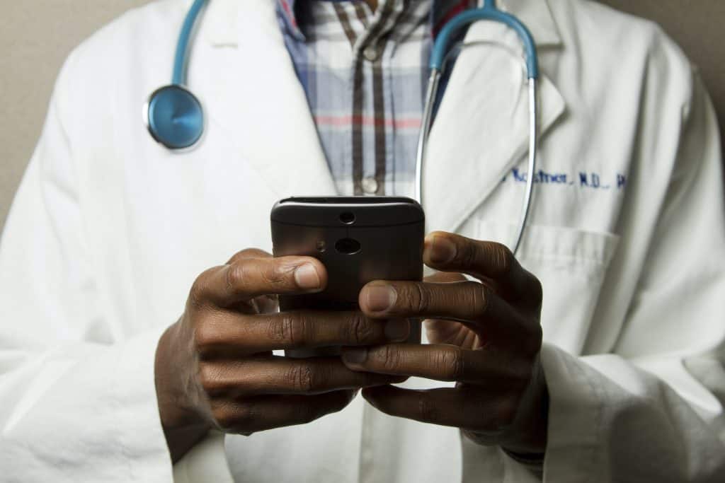 doctor with stethoscope holding a phone